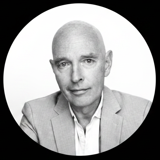Edit the existing portrait of Dan Mapes so his face and shoulders are cropped into a perfect circle, and everything outside the circle is filled with solid pure black. Keep his face, lighting, and overall look the same, just change the crop and outer background.
